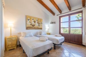 two beds in a room with a window at Son San Marti Gran in Can Picafort +24 photos