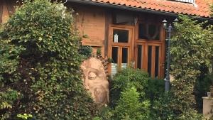 a house with a statue in front of it at Gemütliches Refugium im Klosterdorf in Neustadt am Rübenberge