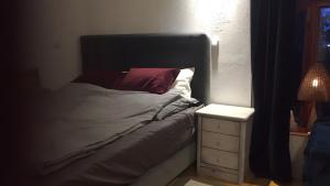 a bed with a black headboard next to a night stand at Gemütliches Refugium im Klosterdorf in Neustadt am Rübenberge