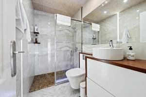 a bathroom with a toilet and a sink and a shower at Apartment with spa and bbq in El Vendrell +18 photos