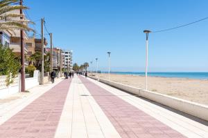 a sidewalk on the beach with people walking on it at Apartment with spa and bbq in El Vendrell