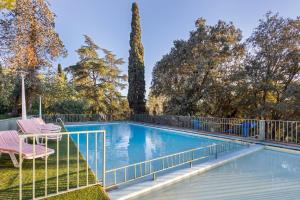 a swimming pool with two chairs and a fence at Tordera Village in Tordera
