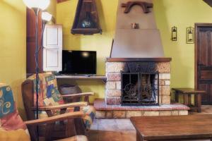 a living room with a stone fireplace with a television at Aldaron in Boca de Huérgano