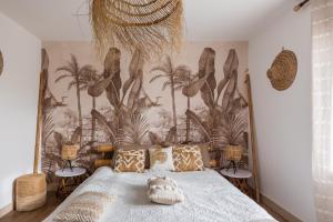 a bedroom with a bed with a mural of palm trees at Gite Du Ptit Lou in Noyers-sur-Cher