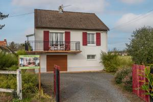 a white house with red shutters and a gate at Gite Du Ptit Lou in Noyers-sur-Cher