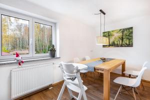 a dining room with a table and chairs and windows at Ferienwohnung am Silberberg in Bodenmais
