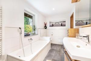 a white bathroom with a tub and a sink at Ferienwohnung am Silberberg in Bodenmais +34 photos