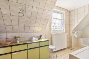 a bathroom with a yellow and white tiled wall at Casa Felicitas Fewo und Studio in Möhnesee +62 photos