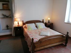 a bedroom with a wooden bed with two night stands at Le Gite du Champ de la Croix in Subligny