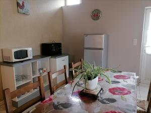 a kitchen with a table and a microwave and a refrigerator at Le Gite du Champ de la Croix in Subligny +4 photos