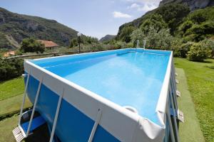 a large blue swimming pool with mountains in the background at Casa Virginia - Corbezzolo in Orco Feglino