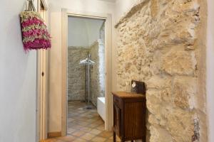 a bathroom with a stone wall and a shower at Casa Virginia - Corbezzolo in Orco Feglino +22 photos
