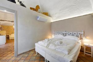 a bedroom with a bed with white sheets at Casa Virginia - Corbezzolo in Orco Feglino