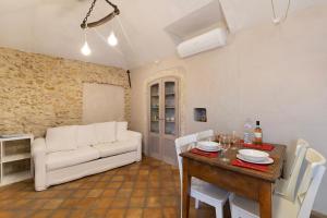 a living room with a white couch and a table at Casa Virginia - Corbezzolo in Orco Feglino