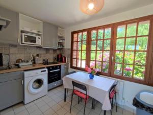 a kitchen with a table with chairs and a sink at Le Relais de Chasse in Eu