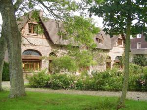 a stone house with trees and flowers in front of it at Le Relais de Chasse in Eu