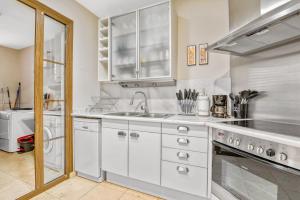 a kitchen with white cabinets and a sink at Villa Gadea 4-2 in Altea