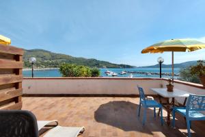 a patio with a table and chairs and an umbrella at Sciabattica - Lacona in Lacona +26 photos