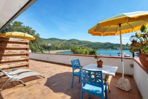 a patio with a table and chairs and an umbrella at Sciabattica - Lacona in Lacona