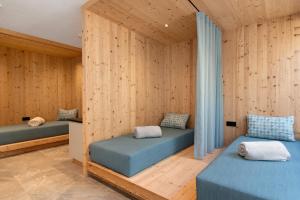 two beds in a room with wooden walls at Mountain Chalet Tribulaun Pflersch in Colle Isarco +86 photos