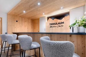 a bar with white chairs and a sign that reads triluvian margaritas at Mountain Chalet Tribulaun Pflersch in Colle Isarco
