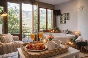 a table with a tray of food and two glasses of wine at El Ablanu, jacuzzi y vistas in Proaza