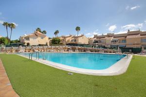 a large swimming pool with lounge chairs in a resort at Exclusive Sonemar in Maspalomas
