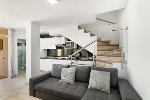 a living room with a couch and a staircase at Exclusive Sonemar in Maspalomas
