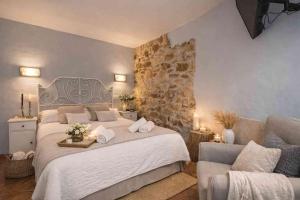 a bedroom with a large bed and a stone wall at El Ablanu, jacuzzi y vistas in Proaza