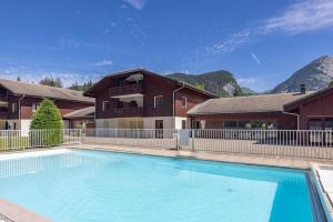 a large swimming pool in front of a house at Appartement à Samoëns – 6 couchages in Samoëns