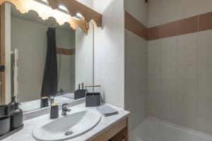 a bathroom with a sink and a mirror and a tub at Appartement à Samoëns – 6 couchages in Samoëns +12 photos