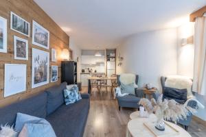 a living room with a blue couch and chairs at Appartement à Samoëns – 6 couchages in Samoëns