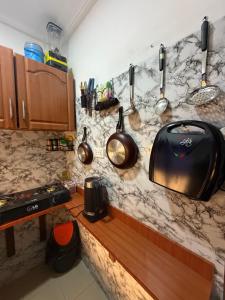 a kitchen with a counter with pots and pans on it at Max Court in Ikeja +9 photos