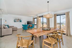 a dining room and living room with a table and chairs at Cana Ferrera in Port de Pollensa