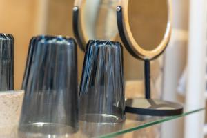 three glass vases sitting on a glass counter with a mirror at Ferienwohnung Zwiesel in Wackersberg