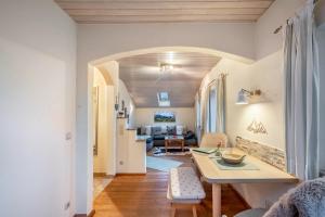 a living room with a table and a kitchen at Ferienwohnung Zwiesel in Wackersberg