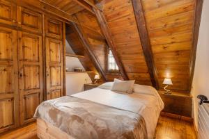 a bedroom with a bed in a room with wooden walls at Casa aranesa en centro de Arties in Arties