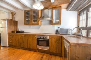 a kitchen with wooden cabinets and stainless steel appliances at Casa aranesa en centro de Arties in Arties