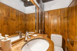 a bathroom with wooden walls and a sink and a toilet at Casa aranesa en centro de Arties in Arties +18 photos