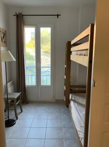 a room with a bunk bed and a door with a window at Maison en Drôme Provençale in Nyons
