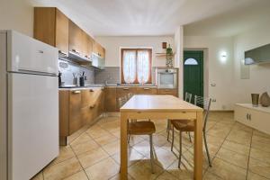 a kitchen with a wooden table and a white refrigerator at Casa Martina in Sassetta
