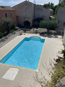 a swimming pool with blue water in a yard at Maison en Drôme Provençale in Nyons