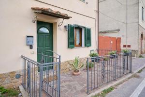 a house with a green door and a gate at Casa Martina in Sassetta