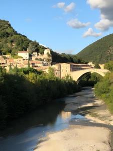 a bridge over a river next to a city at Maison en Drôme Provençale in Nyons