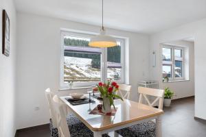 a white dining room with a table and chairs at Ferienwohnung Wanne im Schwarzwald in Furtwangen