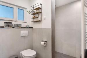 a white bathroom with a toilet and a window at Ferienwohnung Wanne im Schwarzwald in Furtwangen +30 photos
