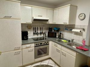 a kitchen with white cabinets and a sink and a clock at Ferienwohnung, Schwerin in Schwerin