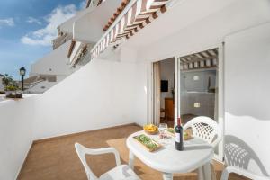 a white dining room with a white table and chairs at Sun and Calm Las Floritas in Playa de las Americas
