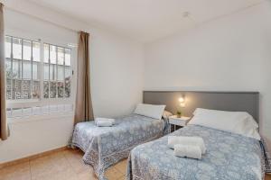 a bedroom with two beds and a window at Sun and Calm Las Floritas in Playa de las Americas