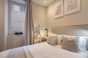 a bedroom with a white bed with a window at Casa Viola in Faro